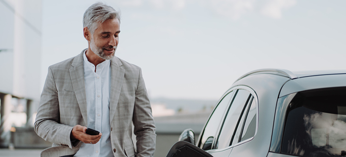 Man looking at electric vehicle charging