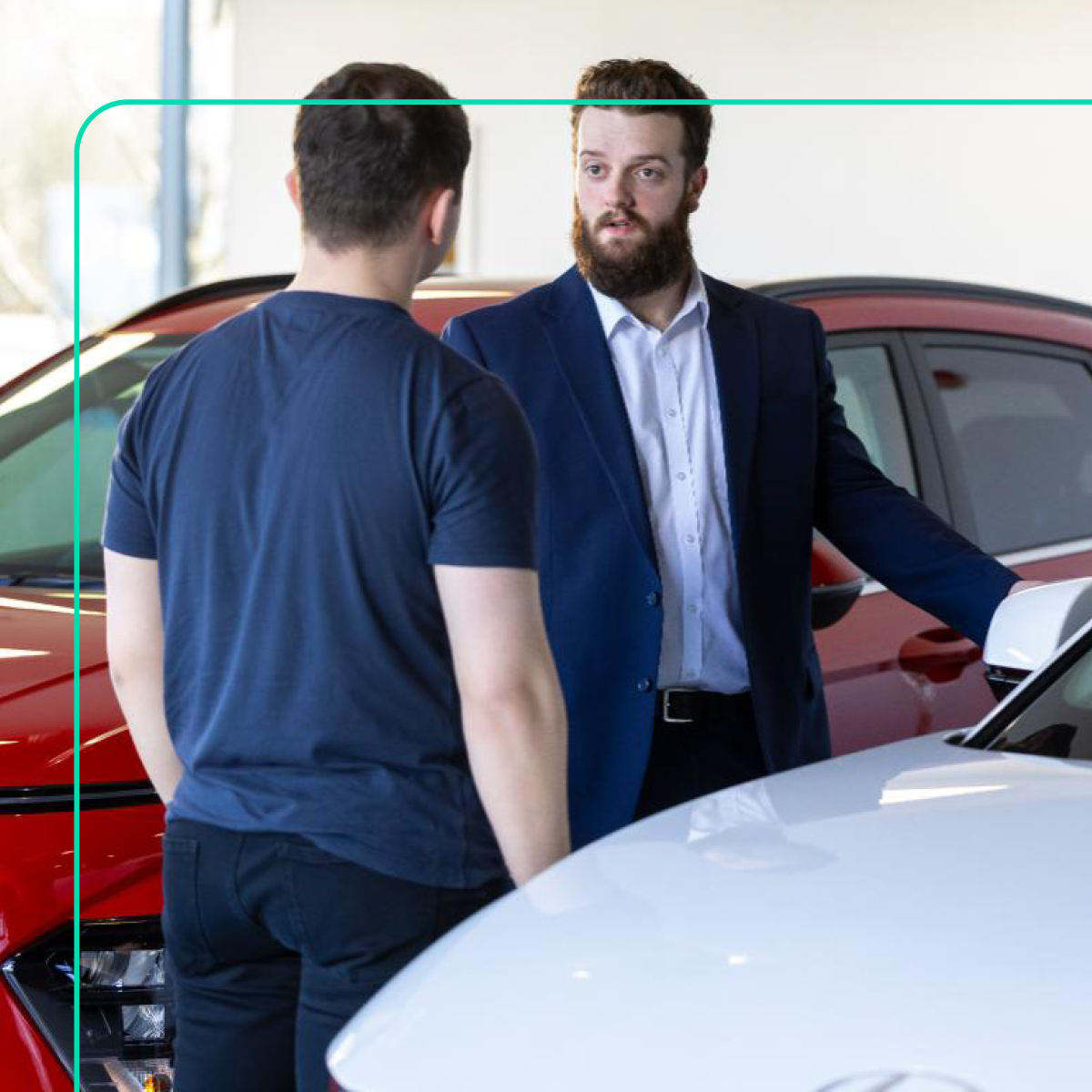 Car dealership sales representative advising customer on new vehicle purchase.
