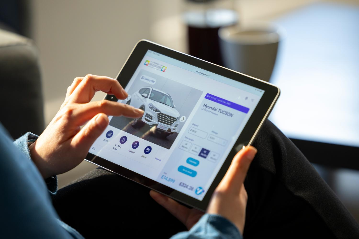 Customer browsing car stock online using a digital retailing tool on a tablet