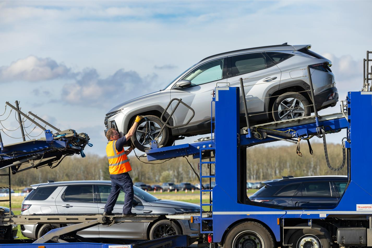 Fleet vehicle being loaded onto car transporter for Cox Automotive fleet logistics