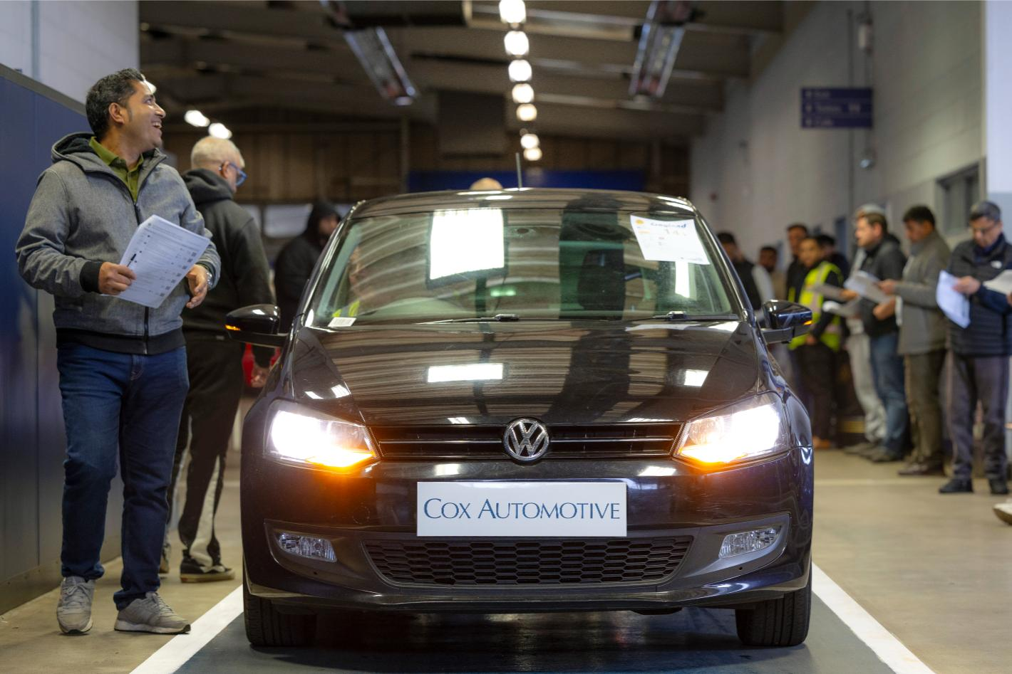 Car at Cox Automotive auction centre with dealers inspecting for vehicle remarketing