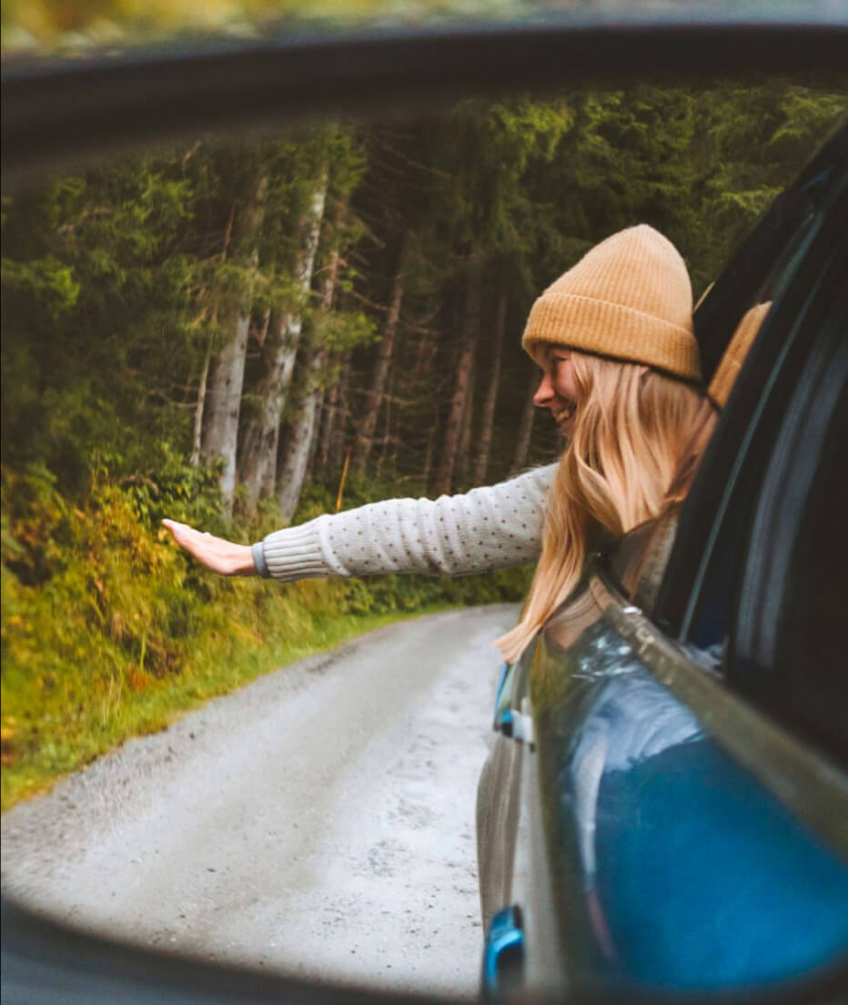 A woman leaning out of the back of a car with an arm extended