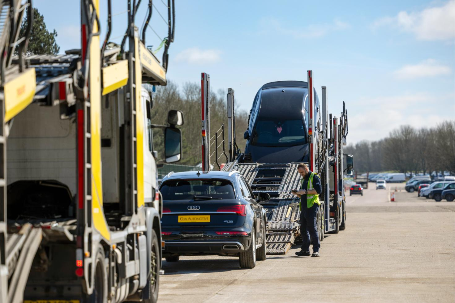 Vehicles being loaded onto car transporters for delivery as part of Cox Automotive logistics service